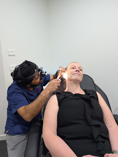 Earport Audiology clinician examining a patient's ear with an otoscope during a clinical appointment